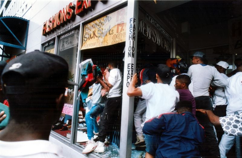 April 30, 1992 - ATLANTA, GA.: Looters worm their way into a clothing store at Five Points after they broke the windows. The crowd swarmed the MARTA Five Points station after being sparked by the Rodney King verdict. (W.A. Bridges Jr/AJC ) 1992