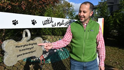 Dr. Humberto Fallas with dogtags, other pet owners have hung, at a memorial of his German shepherd, Ace, near his office Fallas Family Vision in McDonough.(Hyosub Shin / Hyosub.Shin@ajc.com)