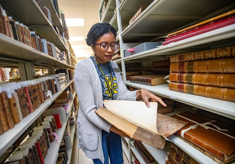 The copy of the Declaration of Independence that Kennesaw State University owns was printed as part of a multivolume book series, shown here by JoyEllen Williams, curator of the Bentley Rare Book Museum at KSU. The copies of the Declaration of Independence were originally folded inside the books, which detail the founding of the United States. (Jenni Girtman for The Atlanta Journal-Constitution)