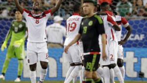 Trinidad and Tobago’s Khaleem Hyland (8) celebrates a teammate’s goal against Mexico during the second half of a CONCACAF Gold Cup soccer match in Charlotte, N.C., Wednesday. (AP Photo/Chuck Burton)