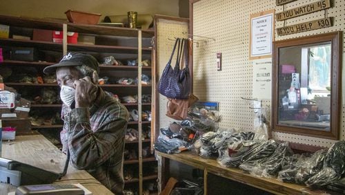 Joe Jordan, 82, owner of Cato Shoe Repair, answers a phone call from a customer inside his store in Atlanta. He and his wife, Hattie, have been repairing shoes since the 1960s. In addition to shoes, they work on belts, purses, luggage and more. (ALYSSA POINTER / ALYSSA.POINTER@AJC.COM)