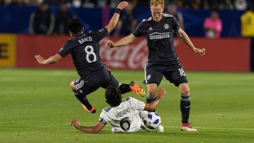 Atlanta United's Jeff Larentowicz and Ezequiel Barco tackle an L.A. Galaxy player during their game on Saturday, April 21, 2018 in Carson, Calif.  (Atlanta United)
