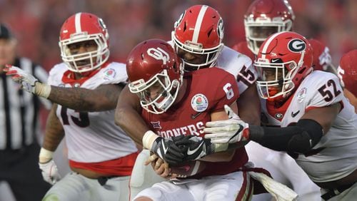 Oklahoma quarterback Baker Mayfield (6) is brought down by Georgia linebacker D'Andre Walker (15) and defensive lineman Tyler Clark (52) in the second half of the College Football Playoff Semifinal at Rose Bowl Stadium in Pasadena, California on Monday, January 1, 2018. Georgia won 54-48 over the Oklahoma. Hyosub Shin / hshin@ajc.com