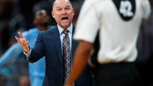 Denver Nuggets head coach Michael Malone, back, argues a call with referee Eric Lewis in the second half of an NBA basketball game against the Atlanta Hawks late Friday, Dec. 23, 2016, in Denver. The Hawks won 109-108. (AP Photo/David Zalubowski)