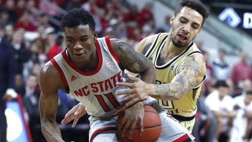 North Carolina State's Markell Johnson (11) drives around Georgia Tech's Jose Alvarado (10) during the first half of an NCAA college basketball game in Raleigh, N.C., Wednesday, March, 6, 2019. (Ethan Hyman/The News & Observer via AP)