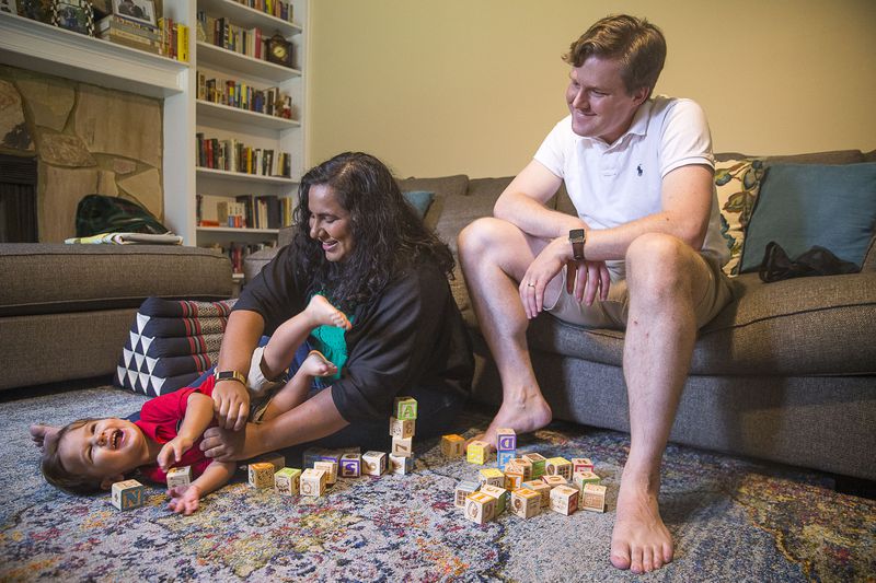  John Henry Theiss (right) watches his wife Sunita Theiss (center) plays with their son, John Sunil Theiss at their residence in Lawrenceville, Saturday, September 14, 2019.  (Alyssa Pointer/alyssa.pointer@ajc.com)