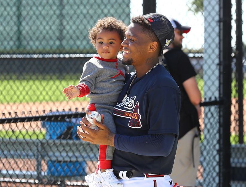 031722 North Port: Atlanta Braves outfielder Ronald Acuna is all smiles playing with his son Ronald Acuna Jr. II after he finishes up batting practice during Spring Training on Thursday, March 17, 2022, in North Port.    “Curtis Compton / Curtis.Compton@ajc.com”