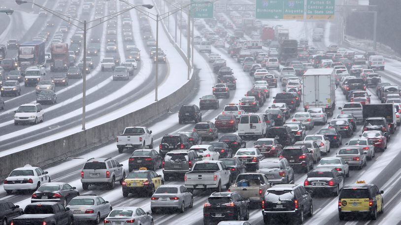 Traffic inches along the Connector as snow blankets the Metro on Tuesday afternoon January 28, 2014 as seen from the Pryor Street overpass. BEN GRAY / AJC File Photo