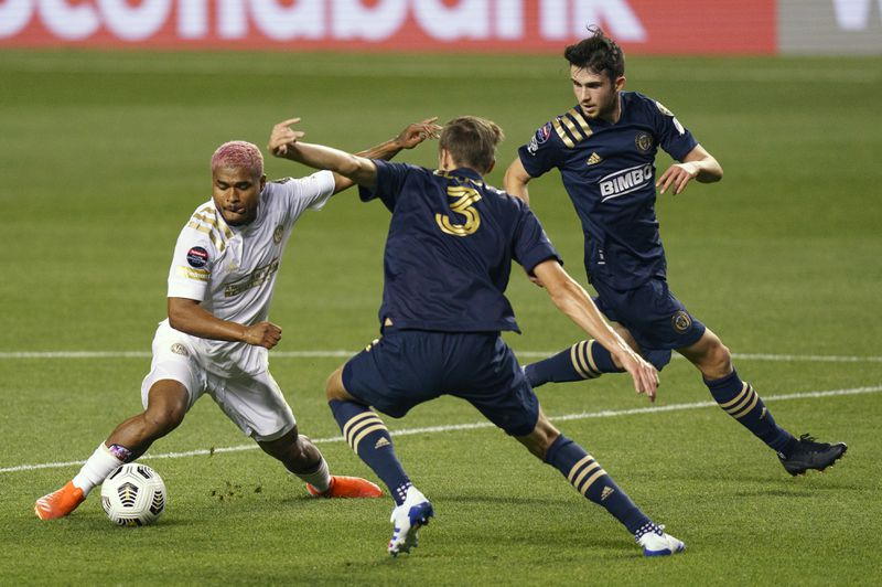 Atlanta United's Josef Martinez, left, battles with Philadelphia Union's Jack Elliott, center, for the ball as Philadelphia Union's Leon Flach, right, looks on during the first half of a CONCACAF Champions League soccer match, Tuesday, May 4, 2021, in Chester, Pa. (AP Photo/Chris Szagola)