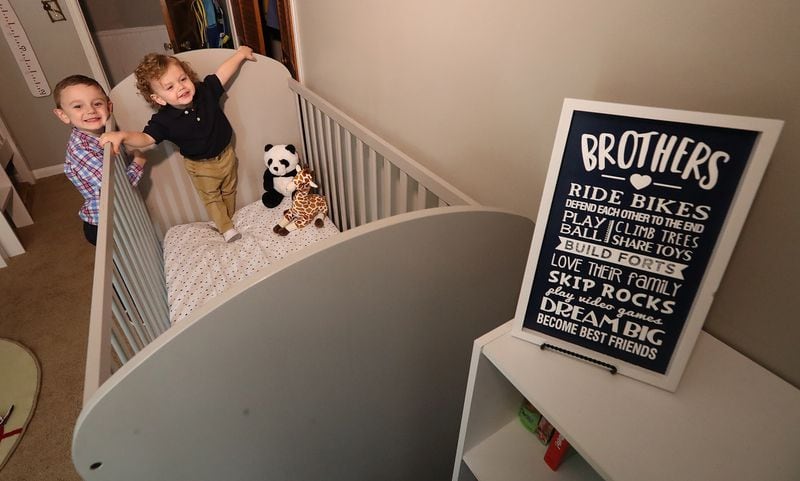Connor (left), 5, and Harrison Lambert, 2, are eager for the arrival of their baby brother Hank. Their baby brother's crib has been set up in their bedroom. (Curtis Compton / Curtis.Compton@ajc.com)
