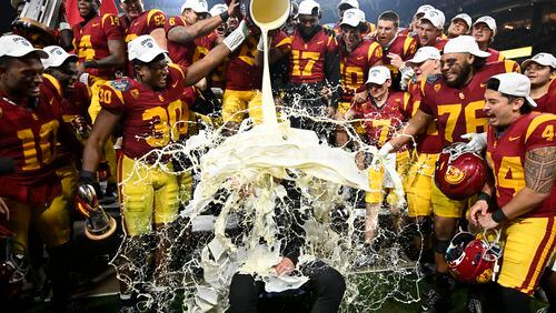 FILE - Southern California coach Lincoln Riley has eggnog poured onto him after USC defeated Louisville in the Holiday Bowl NCAA college football game, Wednesday, Dec. 27, 2023, in San Diego. With the expanded College Football Playoff locked in through 2031, questions still remain about what the rest of the postseason will look like. One thing is certain, there will still be bowl games. (AP Photo/Denis Poroy, File)