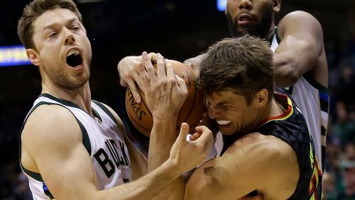 Atlanta Hawks’ Kyle Korver, middle, is defended by Milwaukee Bucks’ Matthew Dellavedova, left, and Greg Monroe, right, during the second half of an NBA basketball game Friday, Dec. 9, 2016, in Milwaukee. The Hawks won 114-110. (AP Photo/Aaron Gash)