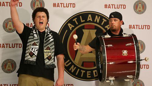 Michael Collier (left) and Kevin Cheek, with Atlanta soccer support group Terminus Legion, chant and cheer before Atlanta United FC announcement.