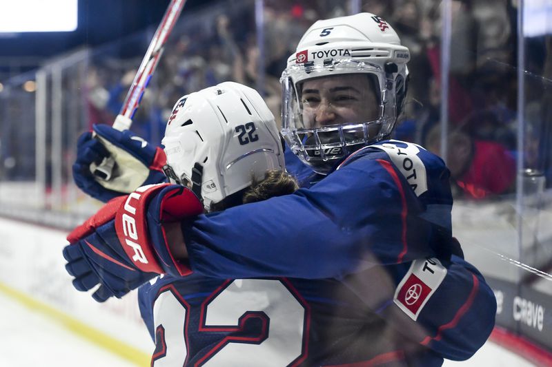 United States' Megan Keller, right, celebrates with forward Tessa Janecke (22) after scoring against Canada during the second period in the final at the women's world hockey championships in Utica, N.Y., Sunday, April 14, 2024. (AP Photo/Adrian Kraus)