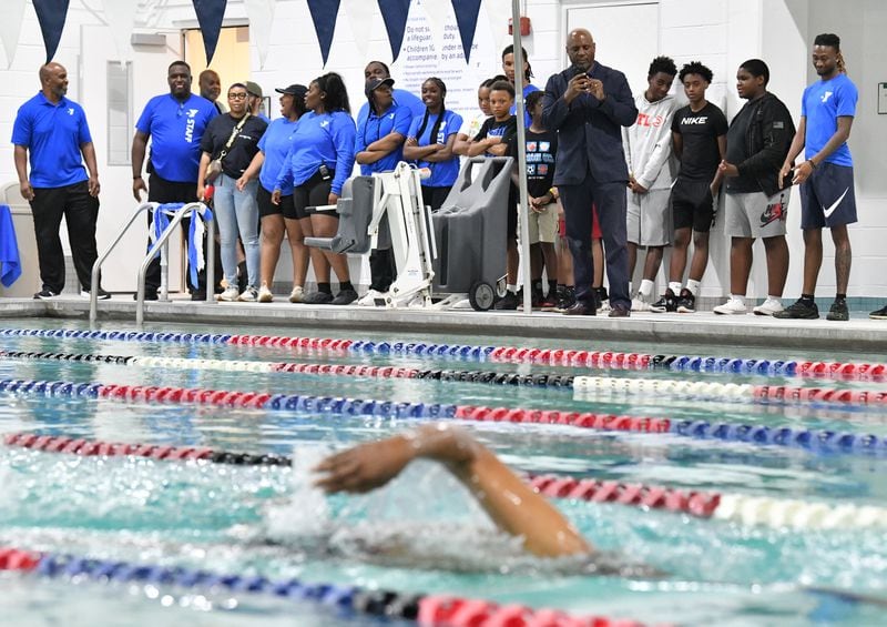 Staff and guests watch as Rev. Gerald Durley (foreground) participates in ceremonial swim during a ribbon cutting ceremony to inaugurate the new pool at Andrew and Walter Young Family YMCA, Wednesday, July 5, 2023, in Atlanta. (Hyosub Shin / Hyosub.Shin@ajc.com)