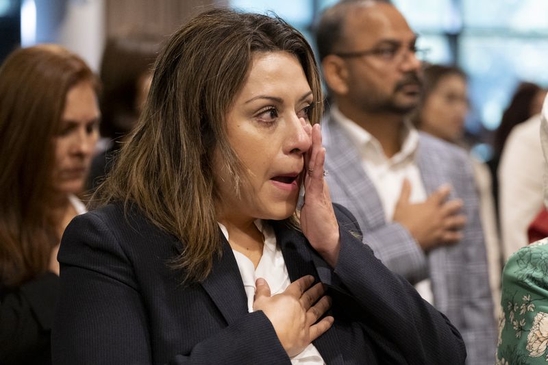 Cintia Harris, from Argentina, wipes away a tear during the Pledge of Allegiance during a ceremony where she became a naturalized citizen at The Carter Center in Atlanta on Sunday, Oct. 1, 2023. The ceremony was held at the center in honor of President Jimmy Carter’s 99th birthday.   (Ben Gray / Ben@BenGray.com)