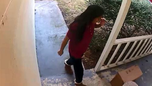 Frame captured from Norcross resident’s video: Christoper Garber said his motion-activated camera captured her walking up, stealing his stuff, then walking back to a car and driving off. Earlier in the day, the camera had captured the UPS man delivering the packages. (WSB-TV)