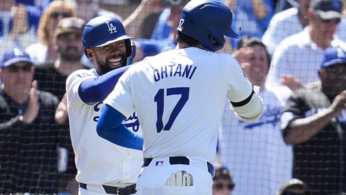 Los Angeles Dodgers designated hitter Shohei Ohtani celebrates with Teoscar Hernández, left, after hitting a home run during the eighth inning of a baseball game against the Atlanta Braves in Los Angeles, Sunday, May 5, 2024. (AP Photo/Ashley Landis)