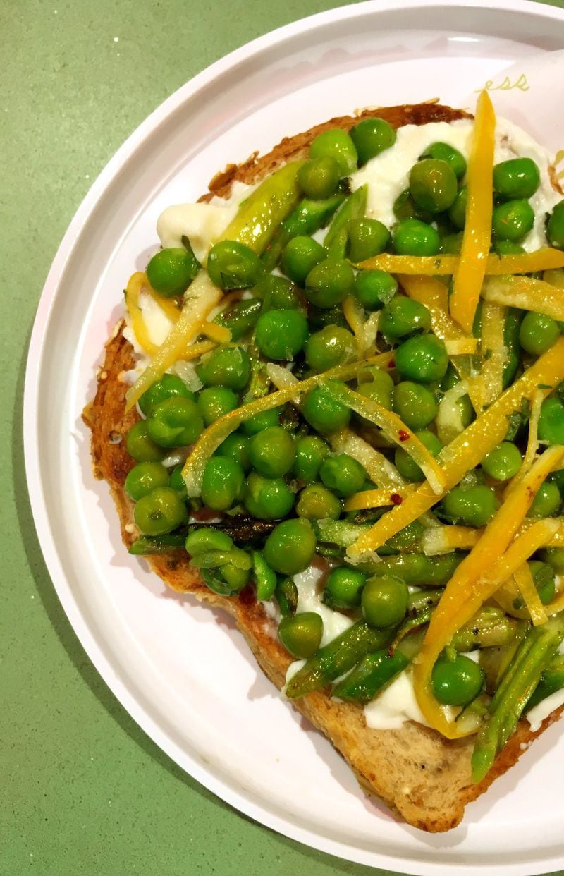 Multigrain toast is topped with spreadable ricotta, spring peas, asparagus, and preserved lemon at Recess. CONTRIBUTED BY WYATT WILLIAMS