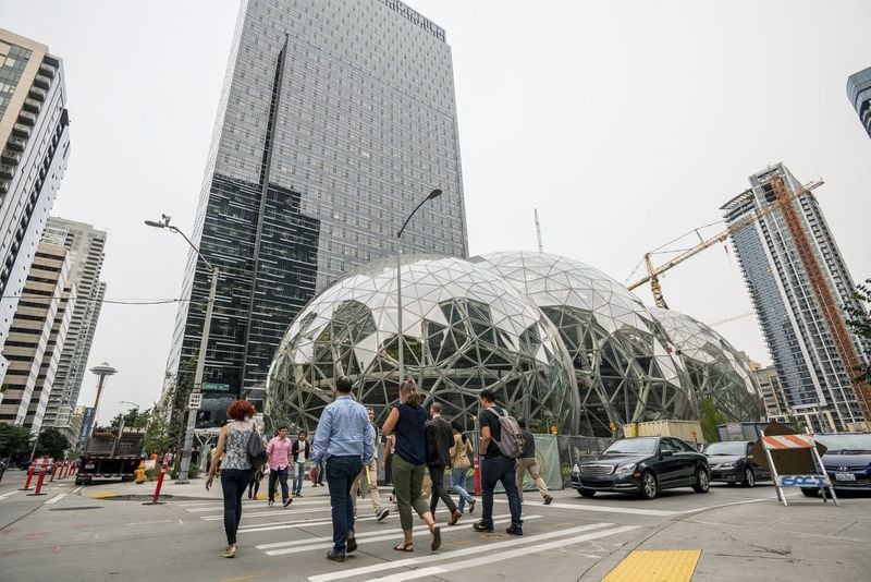 Pedestrians walk past a recently built trio of geodesic domes that are part of the Seattle headquarters for Amazon, Sept. 7, 2017. The online retail giant said it was searching for a second headquarters in North America in 2017, a huge new development that would cost as much as $5 billion to build and run, and house as many as 50,000 employees. (Stuart Isett/The New York Times)