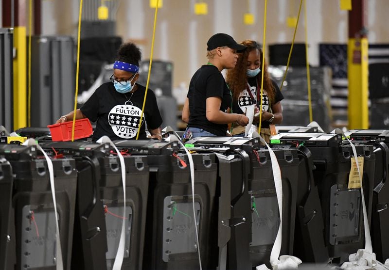 Fulton County election workers prepare voting machines for storage following the 2022 primary.