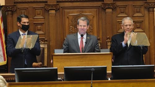 Lt. Gov. Geoff Duncan, left, and House Speaker David Ralston, right, welcome Gov. Brian Kemp for his annual State of the State address to the Georgia Assembly on Thursday, Jan. 13, 2022. During his speech, Kemp said he would work with lawmakers this year to keep "divisive ideologies like critical race theory" out of schools. (Ben Gray for The Atlanta Journal-Constitution)