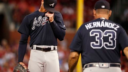 Braves starting pitcher Mike Foltynewicz, left, wipes his face as pitching coach Chuck Hernandez walks out to the mound during the second inning. (AP Photo/Jeff Roberson)