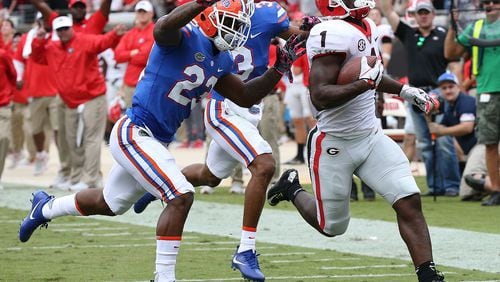 Georgia tailback Sony Michel gets past Florida defenders on a  touchdown run  last week.