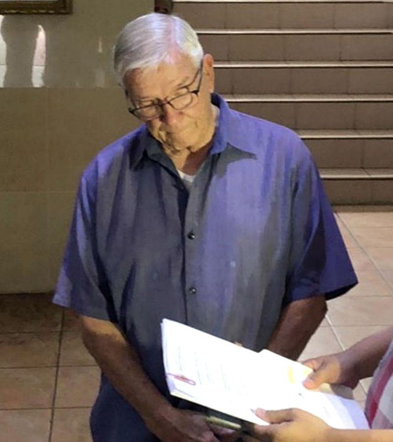 In this Dec. 5, 2018, photo released by the Bureau of Immigration Public Information Office, American Roman Catholic priest Rev. Kenneth Bernard Hendricks looks at documents after being arrested in a church in Naval in the island province of Biliran, central Philippines. Philippine immigration authorities say Hendricks, 77, is accused of sexually assaulting altar boys in a case one official described as "shocking and appalling."