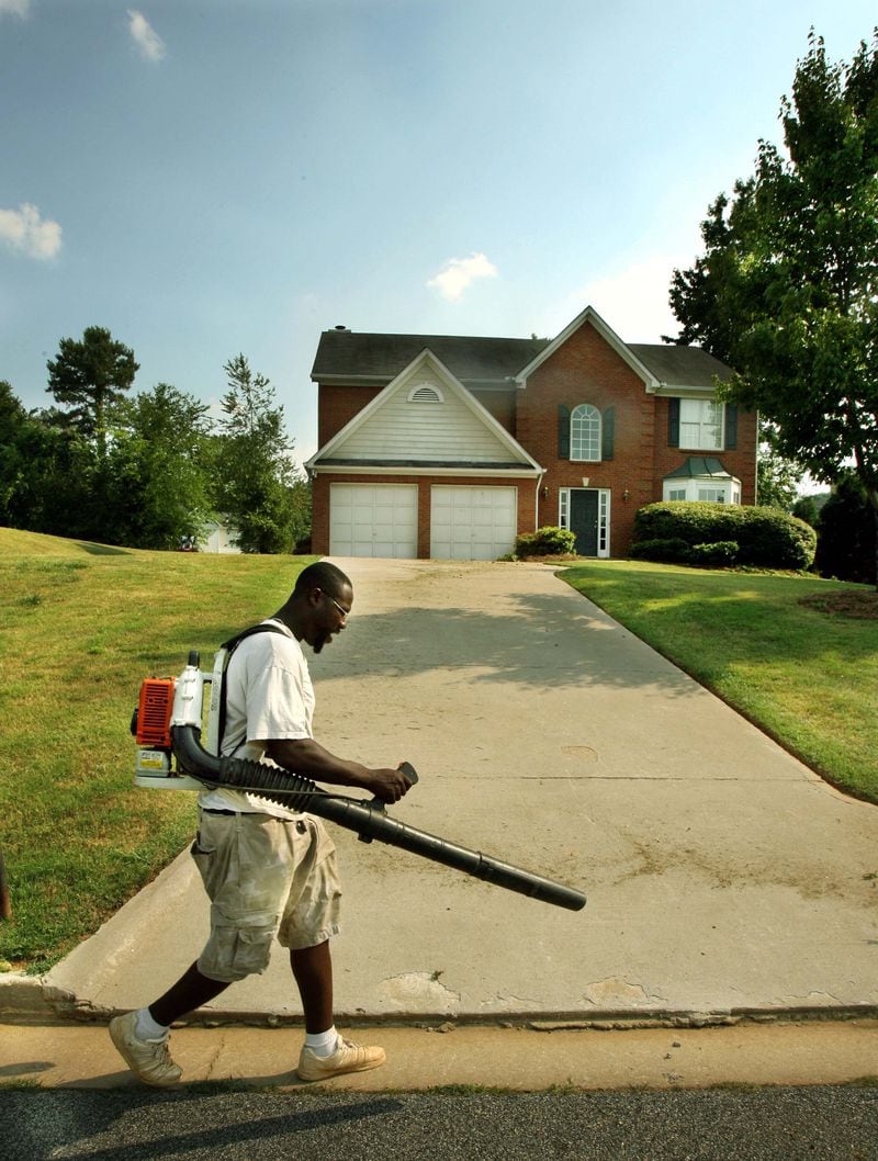 John Ramsey Jr. works on a customer's lawn in the Promenade Oaks subdivision in Atlanta.  (JOEY IVANSCO/ 2006 AJC FILE)
