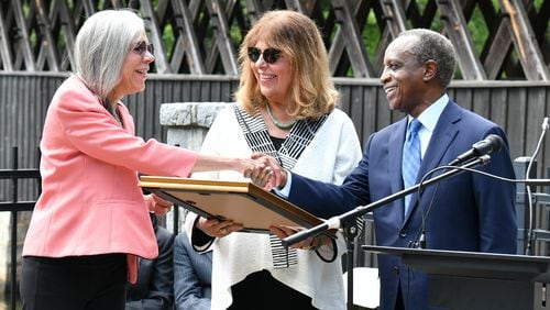 September 16, 2022 Stone Mountain - DeKalb County CEO Michael Thurmond presents a proclamation to Rebecca King Rosenberg (left) and Kathleen King, both great-great-great nieces of Washington W. King during a ceremony to "rededicate" a historic covered bridge at Stone Mountain Park. The bridge built by Washington W. King, a Black bridgebuilder that was the son of freed slaves. It once spanned the Oconee River in Athens but was moved in the 1960s to  Stone Mountain Park’s Indian Island. This covered bridge is one of only four remaining structures of the many created and constructed by Washington W. King. The King family were prominent African-American businessmen for decades in multiple Georgia cities. (Hyosub Shin / Hyosub.Shin@ajc.com)