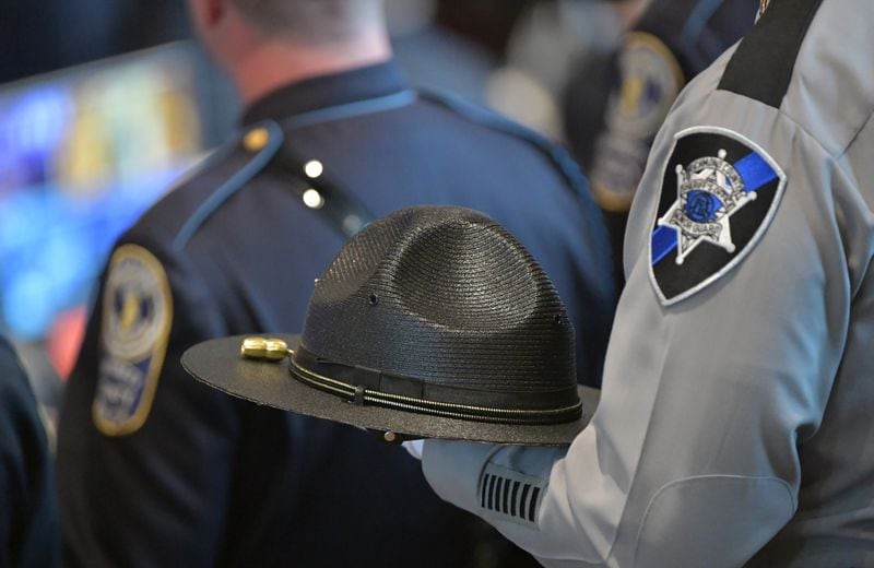 An officer holds a hat to show respect during the funeral service for Officer Chase Maddox at Glen Haven Baptist Church in McDonough on Saturday.