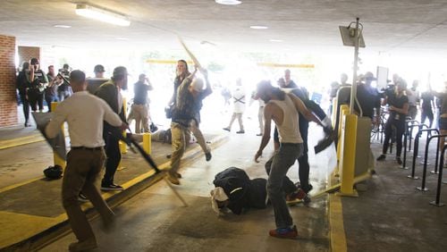 In this Saturday, Aug. 12, 2017 photo, DeAndre Harris, bottom is assaulted in a parking garage beside the Charlottesville police station after a white nationalist rally was disbursed by police. ZACH D. ROBERTS VIA AP