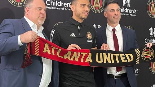 Atlanta United President Garth Lagerwey, Giorgos Giakoumakis and Vice President Carlos Bocanegra pose on Friday at the introduction of the player. (Doug Roberson/The Atlanta Journal-Constitution)