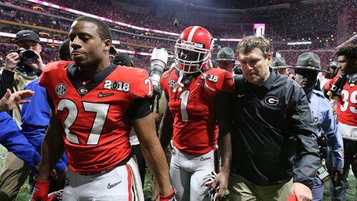 Nick Chubb, Sony Michel, and Kirby Smart walk off the field falling 26-23 to Alabama during over time in the College Football Playoff National Championship on Monday, January 8, 2018, in Atlanta.    Curtis Compton/ccompton@ajc.com