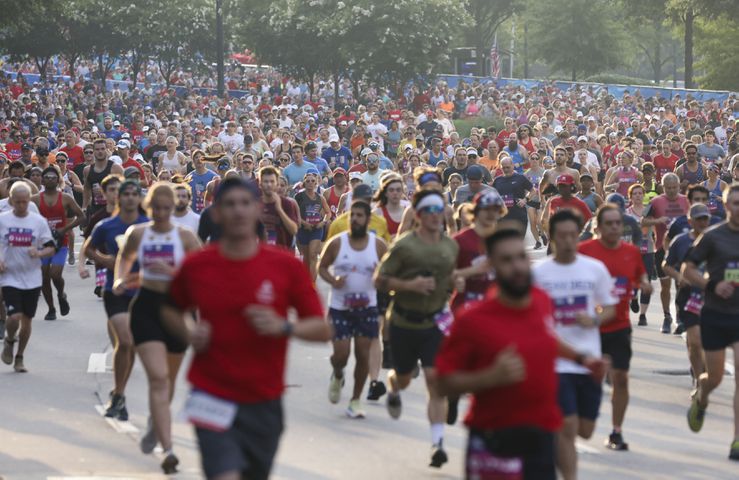 Runners take off at the start of the 53rd running of the Atlanta Journal-Constitution Peachtree Road Race in Atlanta on Monday, July 4, 2022. (Jason Getz / Jason.Getz@ajc.com)