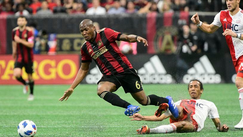 Atlanta United midfielder Darlington Nagbe (6) gets tripped up against the New England Revolution during the first half of an MLS soccer game, Saturday, Oct. 6, 2018. (John Amis)