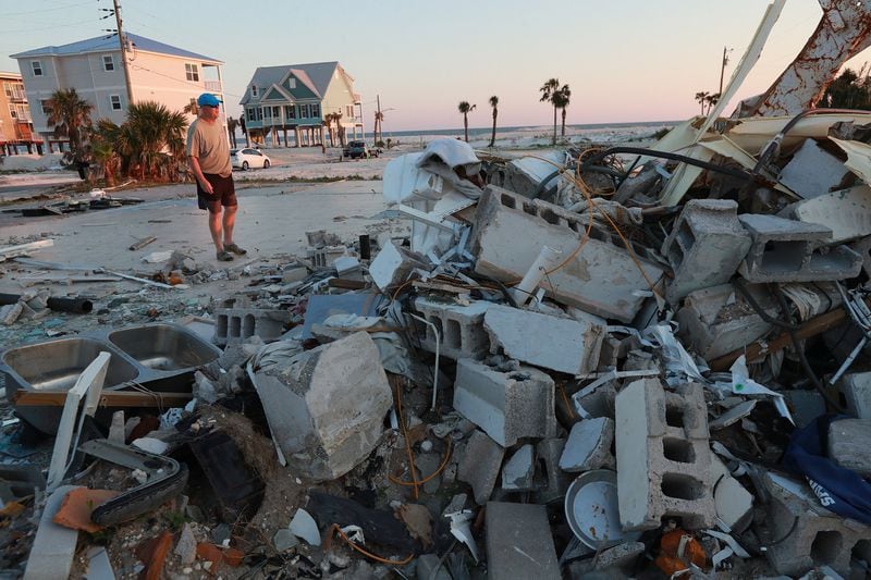 Steve Dwyer of Mexico Beach looks through the remains of a neighbor’s home. He and his wife Gail are the first in their area to move back into their restored home (far left), seven months after Hurricane Michael struck Mexico Beach. The Florida Gulf Coast town lost 80% of the homes to the storm and several of Dwyer’s neighbors lost their lives. 