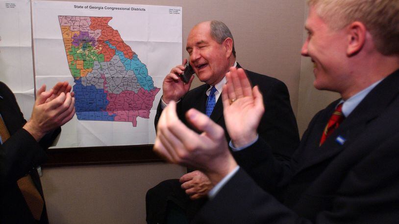021105. ATLANTA. Sonny Perdue cq, Republican candidate for Governor, accepts congratulations on the phone from President Bush. Interestingly, the President's call to Perdue came before Barnes' call. This is taken in Perdue's war room. Right is campaign aide Nick Ayers cq. RICH ADDICKS/STAFF