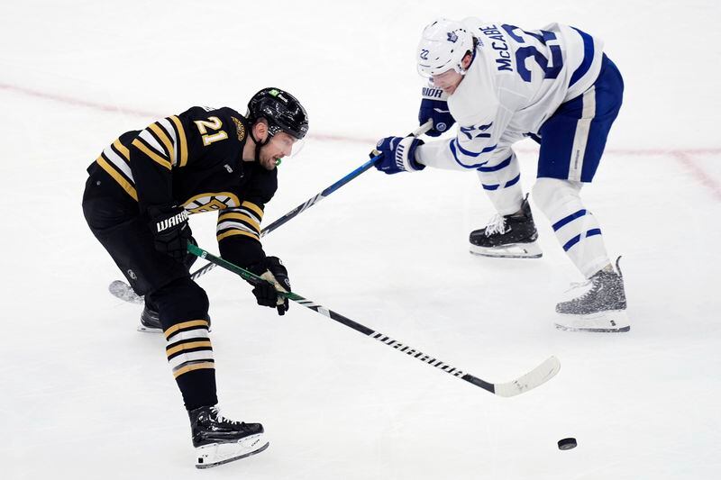 Toronto Maple Leafs' Jake McCabe (22) battles Boston Bruins' James van Riemsdyk (21) for the puck during the first period of Game 7 of an NHL hockey Stanley Cup first-round playoff series, Saturday, May 4, 2024, in Boston. (AP Photo/Michael Dwyer)