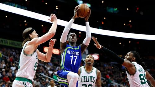 Atlanta Hawks guard Dennis Schroder (17) drives to the basket to shoot as Boston Celtics center Kelly Olynyk (41) and forward Jae Crowder (99) defend in the second half of an NBA basketball game on Thursday, April 6, 2017, in Atlanta. The Hawks won the game 123-116. (AP Photo/Todd Kirkland)