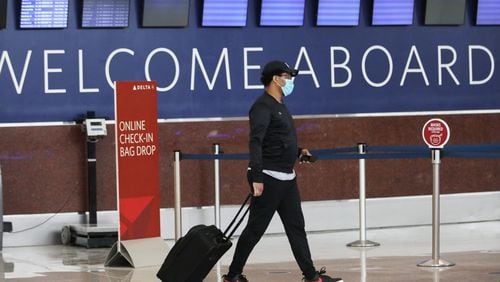 A masked passenger walks through the check-in area at Hartsfield-Jackson Airport's South Terminal on Tuesday, June 23, 2020. Miguel Martinez for The Atlanta Journal-Constitution