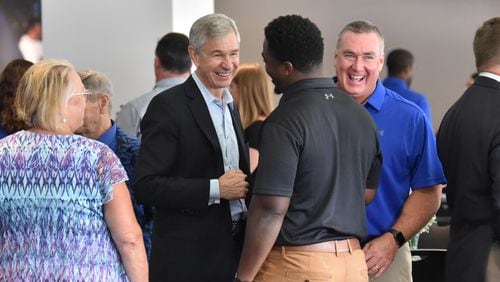 Georgia State University President Mark Becker (center left) and GSU football head coach Shawn Elliott (center right), react as they talk to linebacker Ed Curney (center) during 2019 Football Kickoff Luncheon at Georgia State Stadium on Wednesday, August 14, 2019. When Mark Becker was hired as Georgia State University's president a decade ago, the school was largely considered a commuter campus and a place for adult workers to get their degrees. Today, Georgia State has the largest enrollment of any college, public or private, in the state and has the reputation as one of the best schools in the nation for non-white students to earn their degrees by using data to determine where students need assistance.