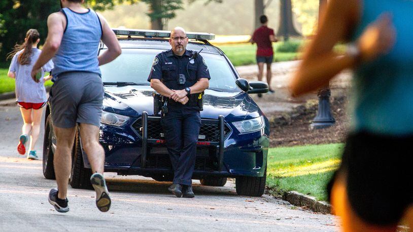 Atlanta police Officer Miguel A. Lugo stands watch in Piedmont Park early Thursday morning, a day after Katherine Janness' body was found with multiple stab wounds.