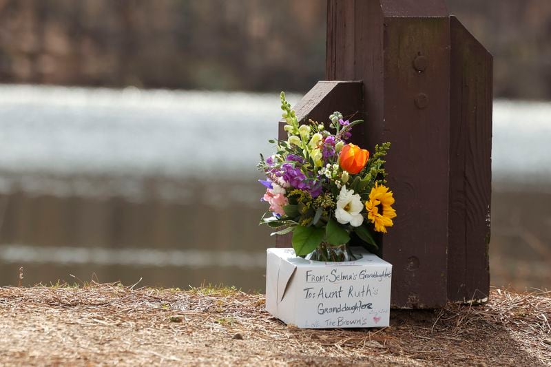 Mourners laid flowers at Lake Herrick in Athens at the University of Georgia on Friday, Feb. 23, 2024. Laken Riley, a 22-year-old nursing student, was found dead nearby on Thursday. (Jason Getz/The Atlanta Journal-Constitution/TNS)