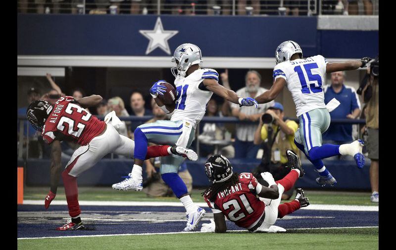 Atlanta Falcons cornerback Robert Alford (23) and cornerback Desmond Trufant (21) are sent flying along with Dallas Cowboys wide receiver Devin Street (15) as running back Joseph Randle (21) scores a touchdown on a running play during the first half of an NFL football game on Sunday, Sept. 27, 2015, in Arlington, Texas. (AP Photo/Michael Ainsworth)