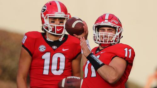 Injured Georgia quarterback Jacob Eason watches as Jake Fromm warms up for the team's game against Mississippi State on Saturday, Sept. 23, 2017, in Athens.