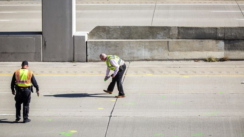 Genesee County Sheriff's officers investigate the scene of a traffic fatality in Vienna Township, Mich.  where a driver was killed when a rock thrown from an overpass on Interstate 75 north of Flint, hit his windshield.