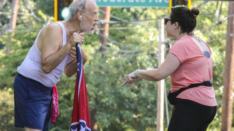 Confederate flag runner Alan Keck (left) debates Grant Park resident Katie Kurumada (right) about the petition to change the name of Confederate Avenue last August. Keck runs in the park three days a week and is concerned about the heritage aspect of Confederate names and symbols. JOHN SPINK/JSPINK@AJC.COM