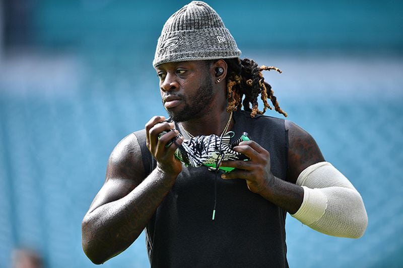 Running back Jay Ajayi of the Philadelphia Eagles adjusts his Adidas cleat during warmups prior to a game in Miami. Black professional athletes wear the Adidas brand proudly, but the few black employees at the company's headquarters describe a workplace culture that contradicts the brand's image as a beacon of diversity.